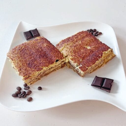 Balade gourmande avec un gâteau à la vanille saupoudré de cacao, accompagné de morceaux de chocolat noir et de grains de café, parfait pour une pause douceur.