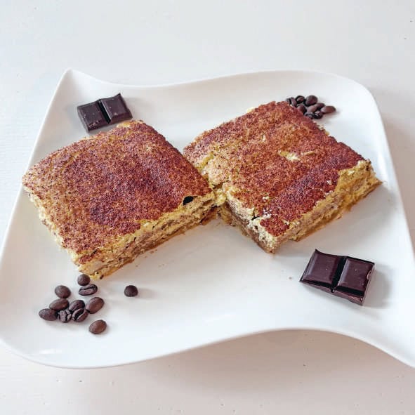 Balade gourmande avec un gâteau à la vanille saupoudré de cacao, accompagné de morceaux de chocolat noir et de grains de café, parfait pour une pause douceur.